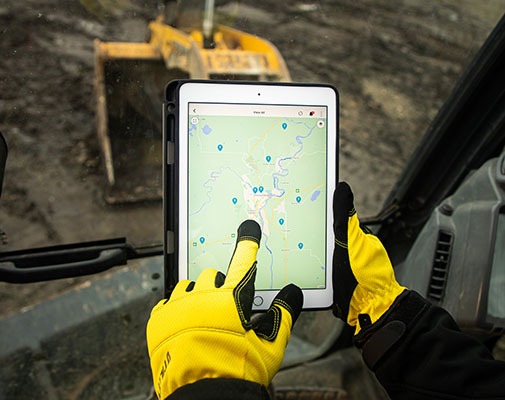 Heavy equipment driver using GPS fleet tracking software on a iPad.